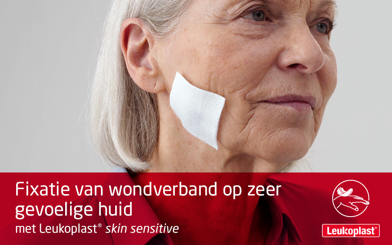 Hier zien we hoe een wondverband op zeer gevoelige huid kan  worden aangebracht en geherpositioneerd  met behulp van fixatiepleister: een zorgprofessional bevestigt een kompres op de wang van een oudere vrouw met een kwetsbare huid met behulp van Leukoplast skin sensitive. Hier zien we hoe een wondverband op zeer gevoelige huid kan  worden aangebracht en geherpositioneerd  met behulp van fixatiepleister: een zorgprofessional bevestigt een kompres op de wang van een oudere vrouw met een kwetsbare huid met behulp van Leukoplast skin sensitive.